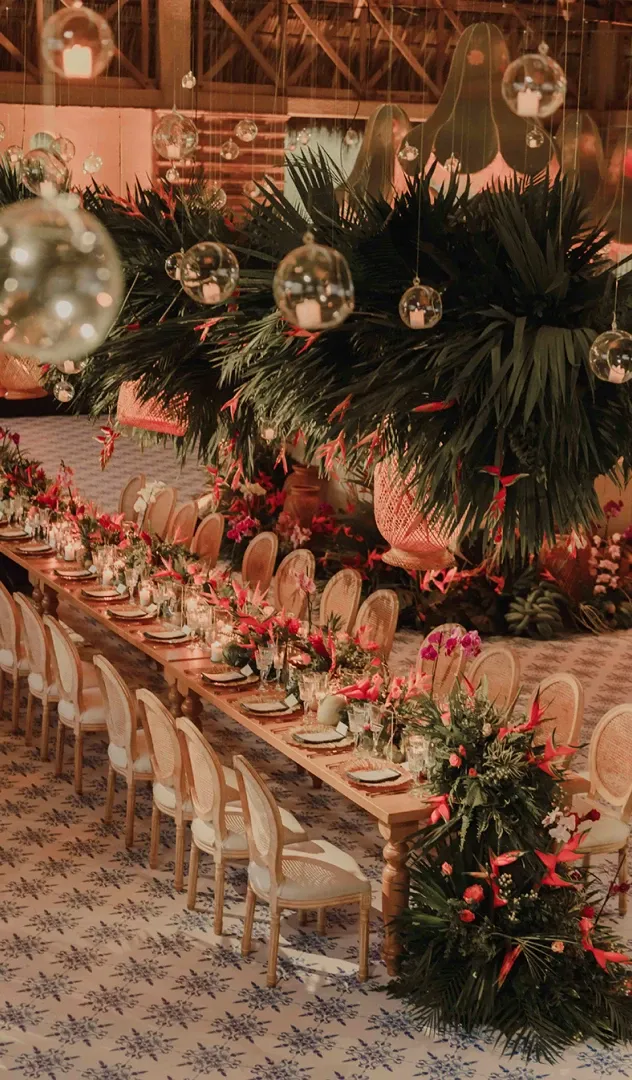 Mesa larga en salón de bodas decorada con flores