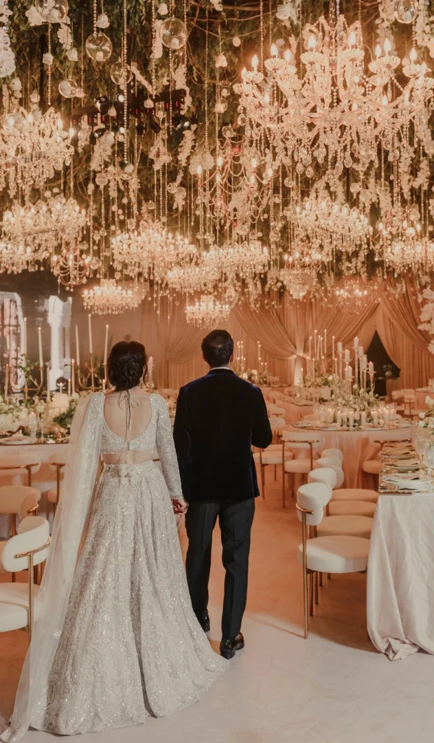 Pareja de casados viendo salón elegante con muchos candelabros