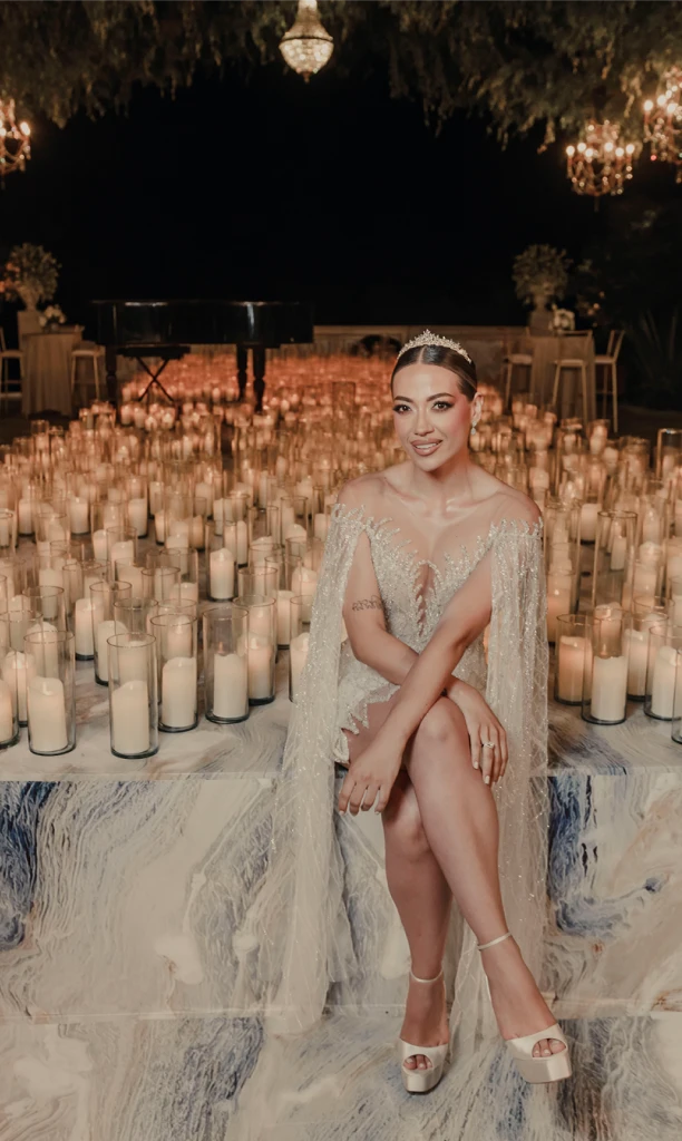 Novia sentada en una tarima llena de velas blancas encendidas