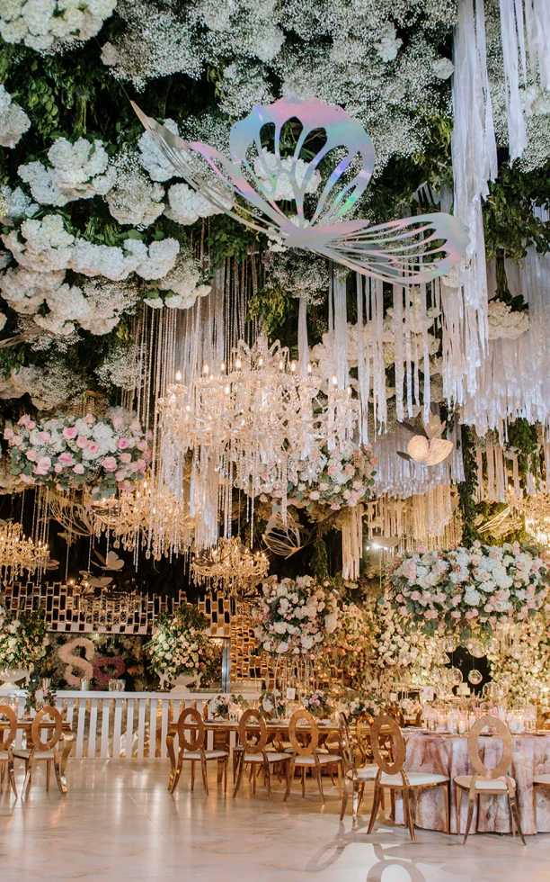 Celebración extraordinaria con arreglos florales y candelabros en el techo