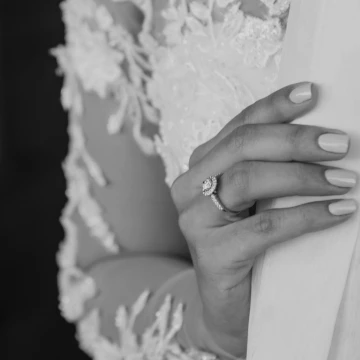 Foto de brazo de una novia, cubierto por el encaje de su vestido blanco