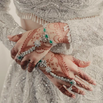 Mano de novia con joyas y tatuajes de henna