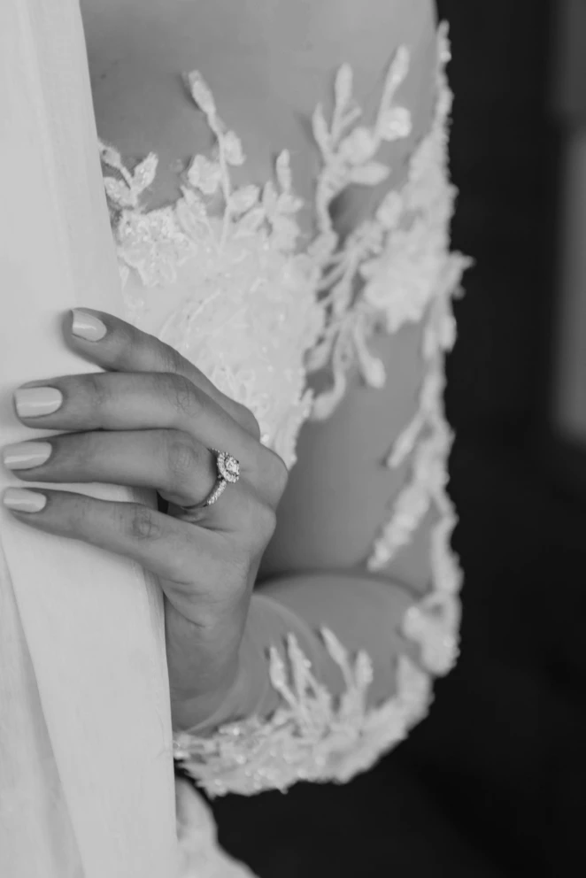 Foto de brazo de una novia, cubierto por el encaje de su vestido blanco